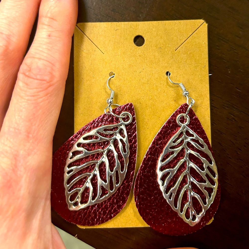 Metal alloy large leaf earrings with leather backing.